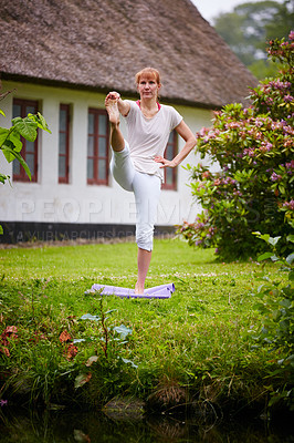 Buy stock photo Shot of a woman practicing yoga in her backyard