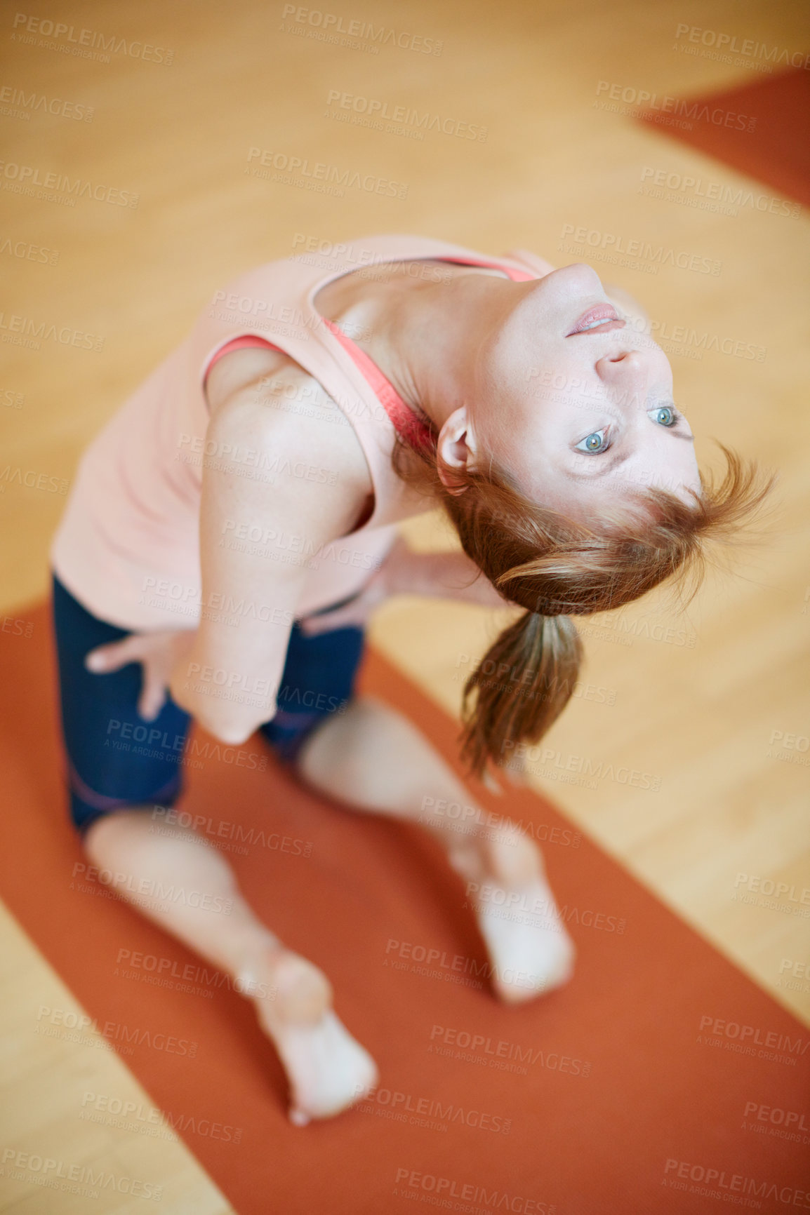 Buy stock photo Shot of a woman doing a backbend during a yoga workout