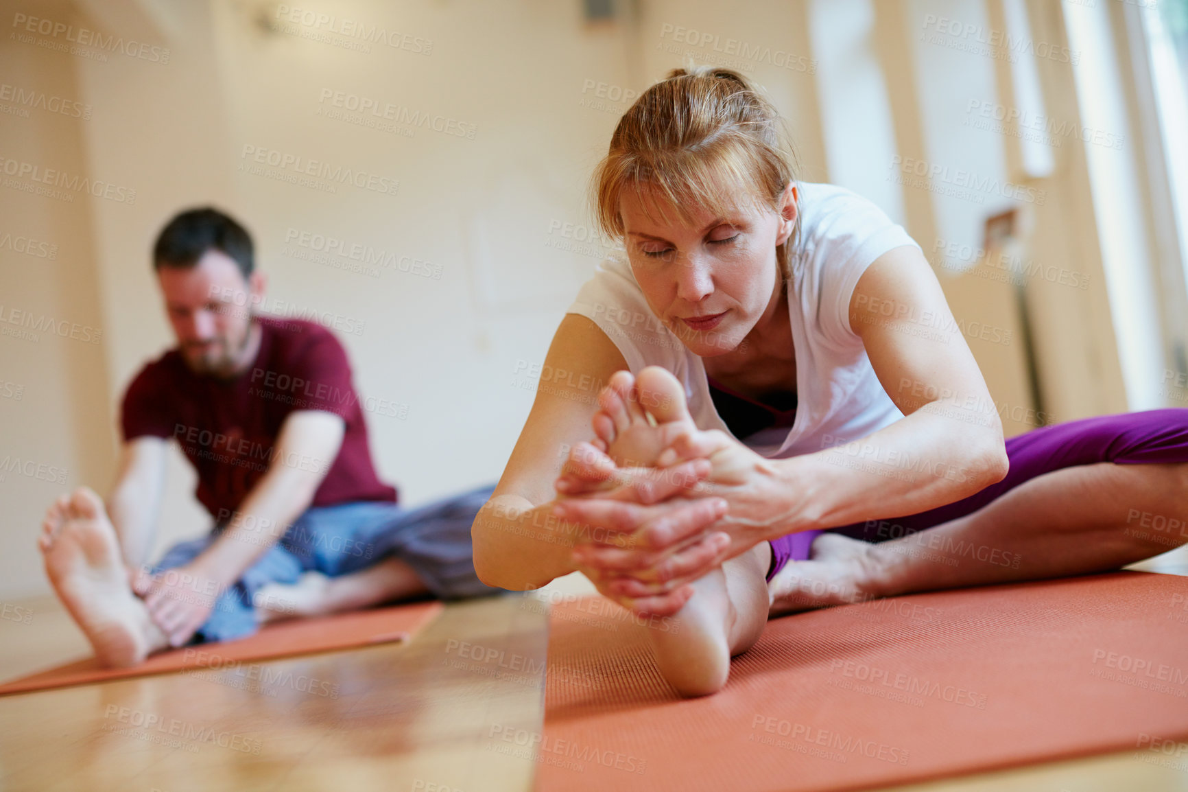 Buy stock photo Shot of two people doing yoga together in a studio