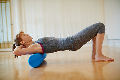 Buy stock photo Shot of a woman doing roller foam exercises during a yoga workout