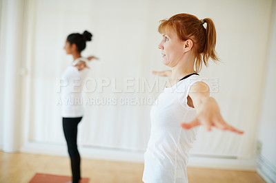 Buy stock photo Shot of two women doing yoga together indoors