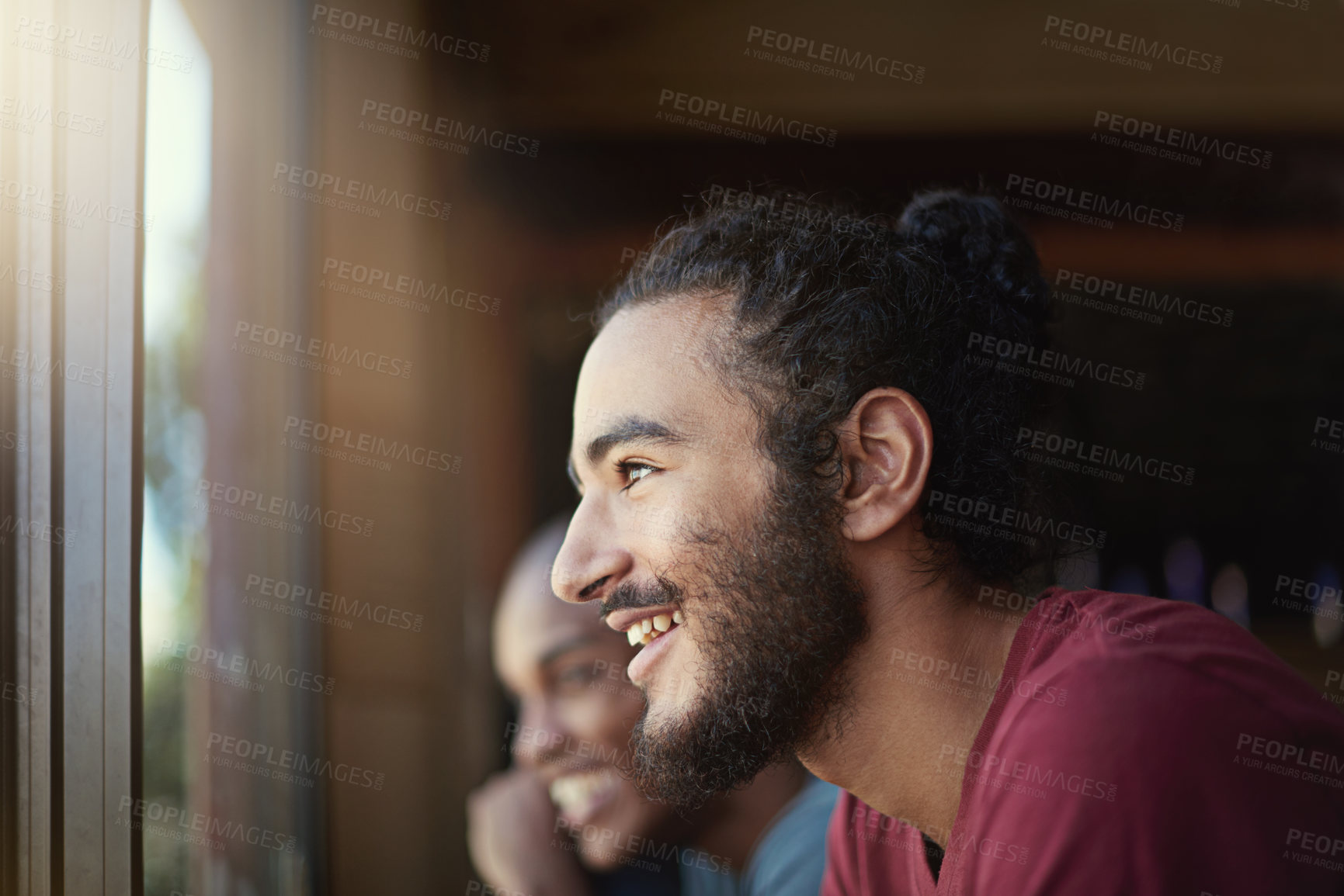 Buy stock photo Shot of a group of laughing friends sitting at a table near a window