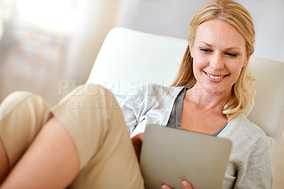 Buy stock photo Shot of a woman using a digital tablet in the living room