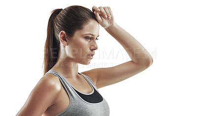 Buy stock photo Cropped shot of a young female athlete wiping the sweat from her brow against white background