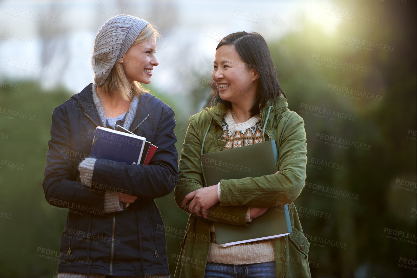 Buy stock photo University, books and conversation with woman friends outdoor on campus together for learning or development. College, education or school with young student and best friend talking at recess break