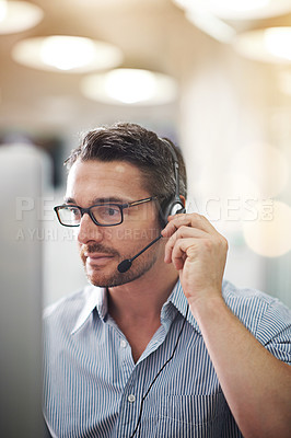 Buy stock photo Cropped shot of a call centre operator sitting at the desk