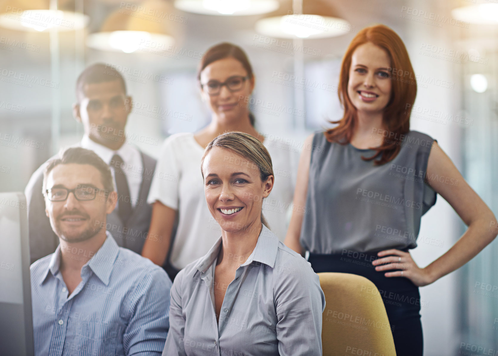 Buy stock photo Portrait of a group of a diverse corporate group standing in an office. Happy smiling colleagues motivated and dedicated to success. Cheerful and ambitious team working together in a startup agency