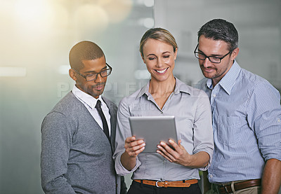 Buy stock photo Cropped shot of three businesspeople working on a digital tablet