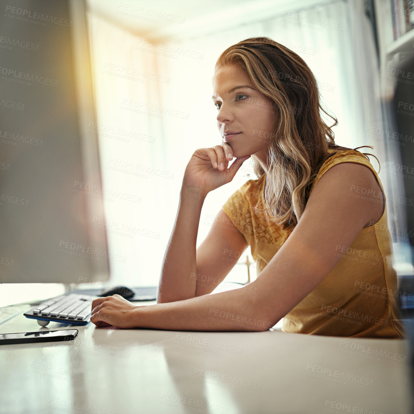 Buy stock photo Shot of a young woman working on a computer in her home office