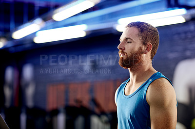 Buy stock photo Shot of a young man standing inside a gym