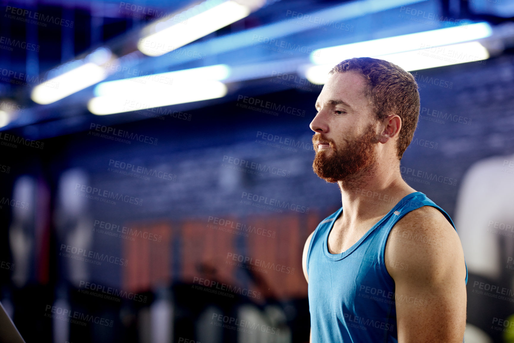 Buy stock photo Shot of a young man standing inside a gym