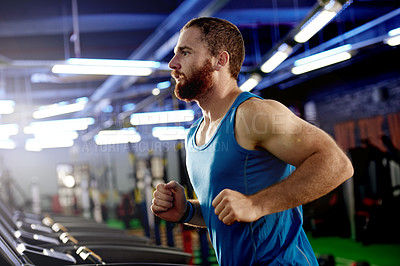 Buy stock photo Shot of a young man working out on a treadmill at the gym