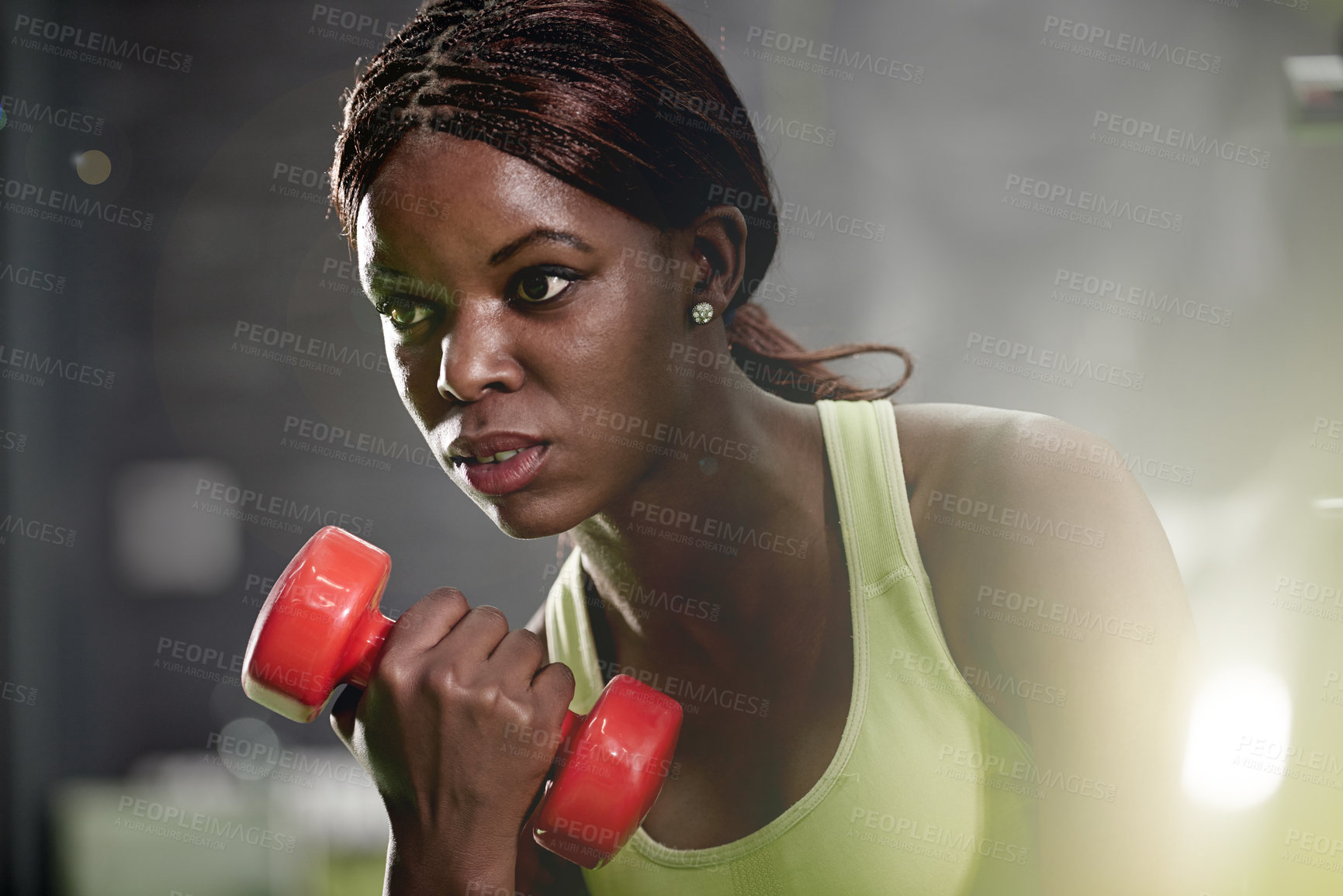 Buy stock photo Shot of a young woman lifting weights at the gym