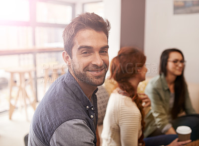 Buy stock photo Portrait of a young sitting in a coffee shop with his friends blurred in the background