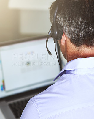 Buy stock photo Over the shoulder shot of a man working on his laptop