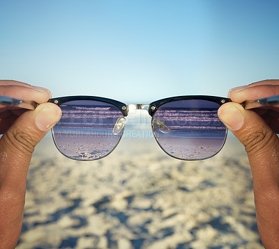 Buy stock photo POV shot of a person at the beach looking at the waves through their sunglasses