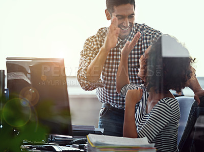 Buy stock photo Cropped shot of two colleagues high fiving in the office