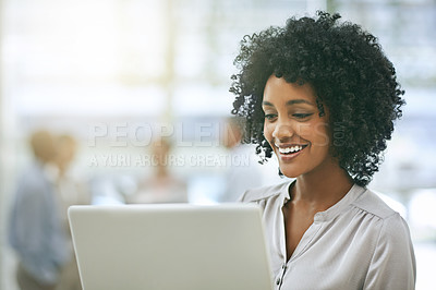 Buy stock photo Cropped shot of a young businesswoman using a laptop with her colleagues in the background