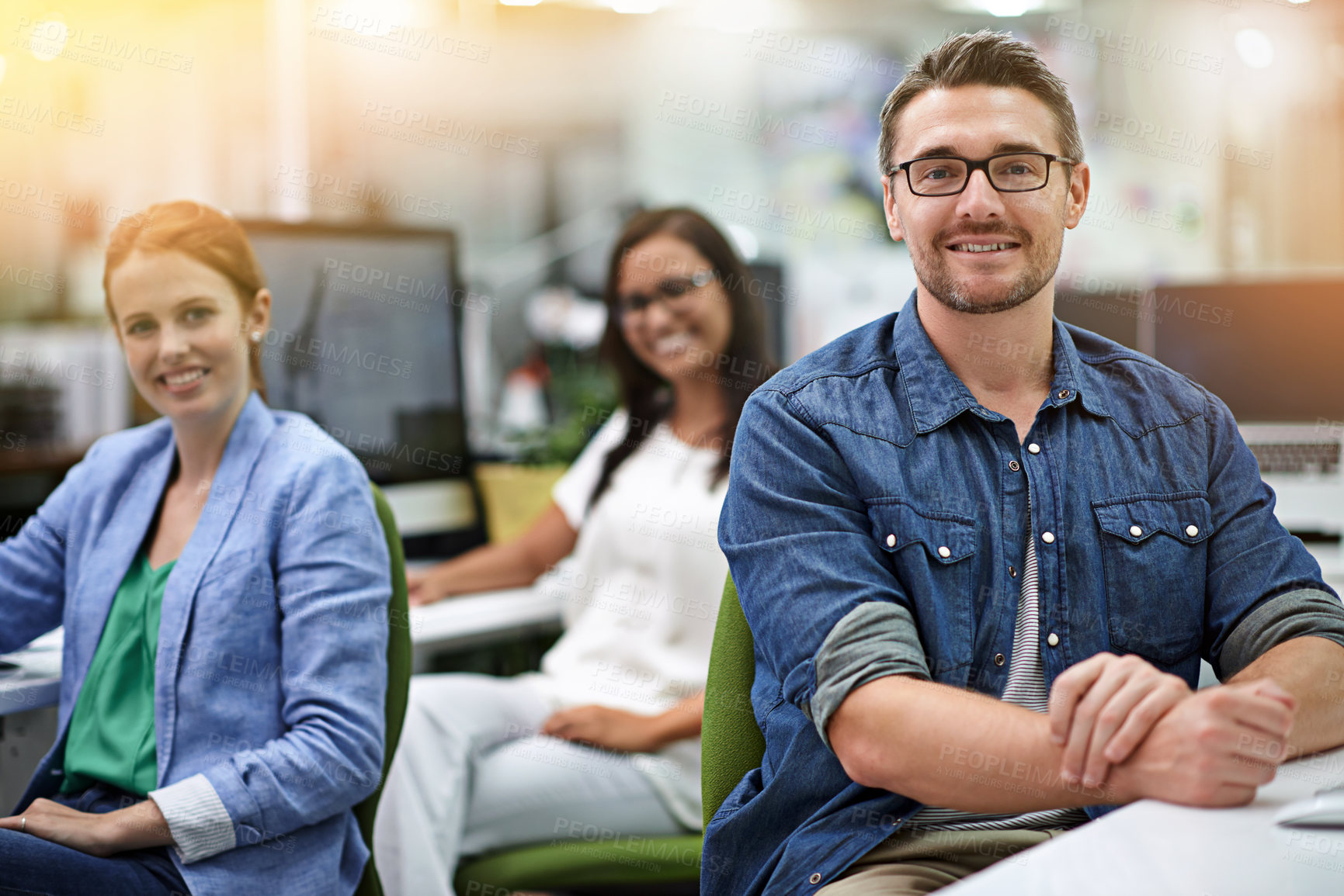 Buy stock photo Cropped portrait of three colleagues sitting in the office