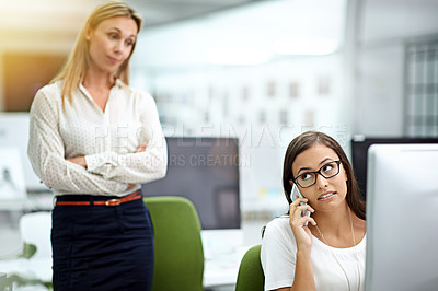 Buy stock photo Cropped shot of a young businesswoman caught on a personal call during work hours