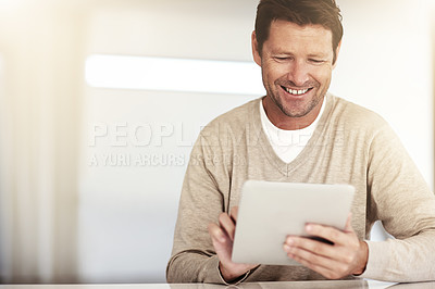 Buy stock photo Cropped shot of a man using his tablet at home