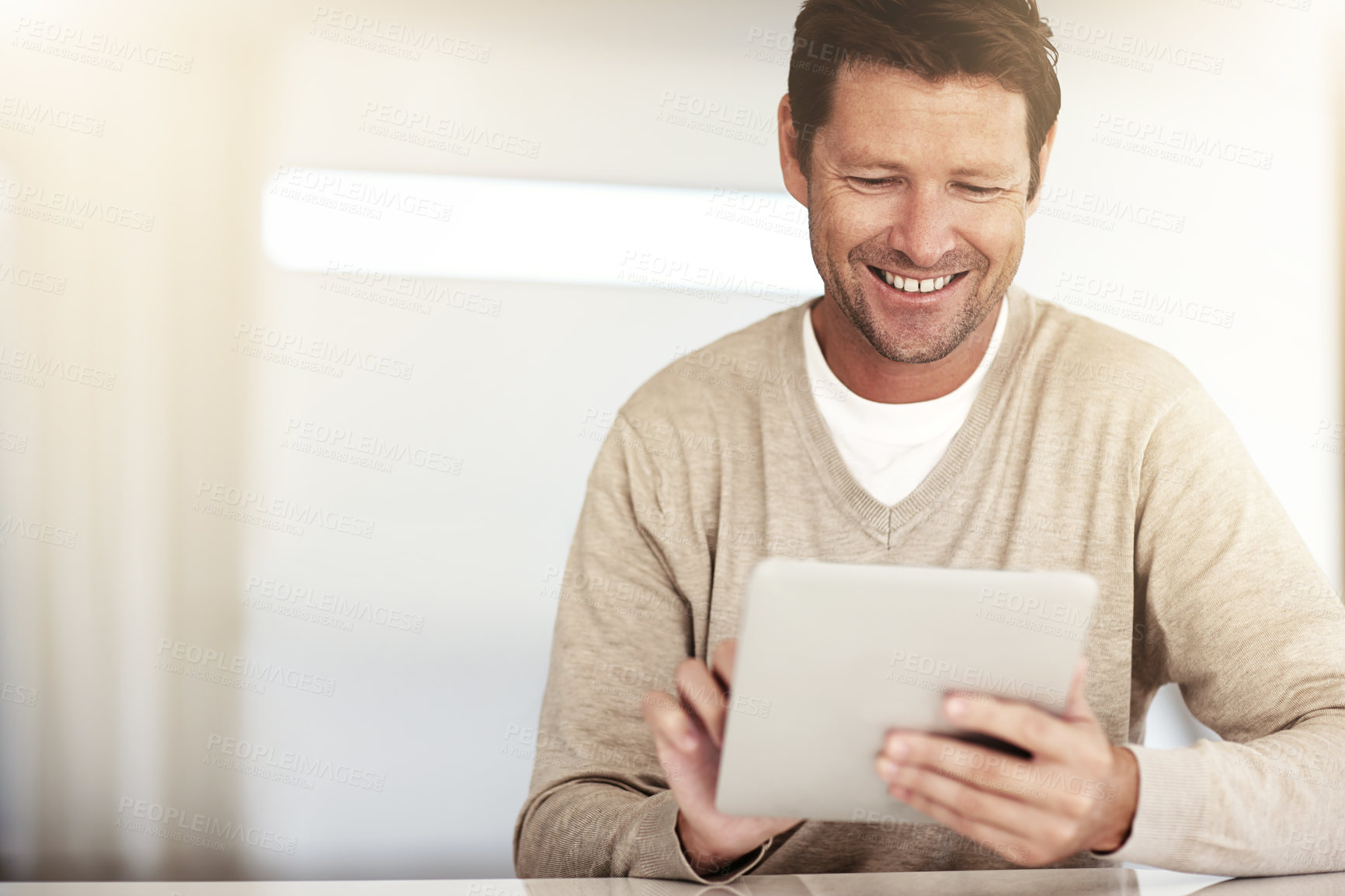 Buy stock photo Cropped shot of a man using his tablet at home