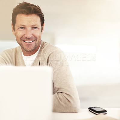 Buy stock photo Cropped portrait of a man using his laptop at home