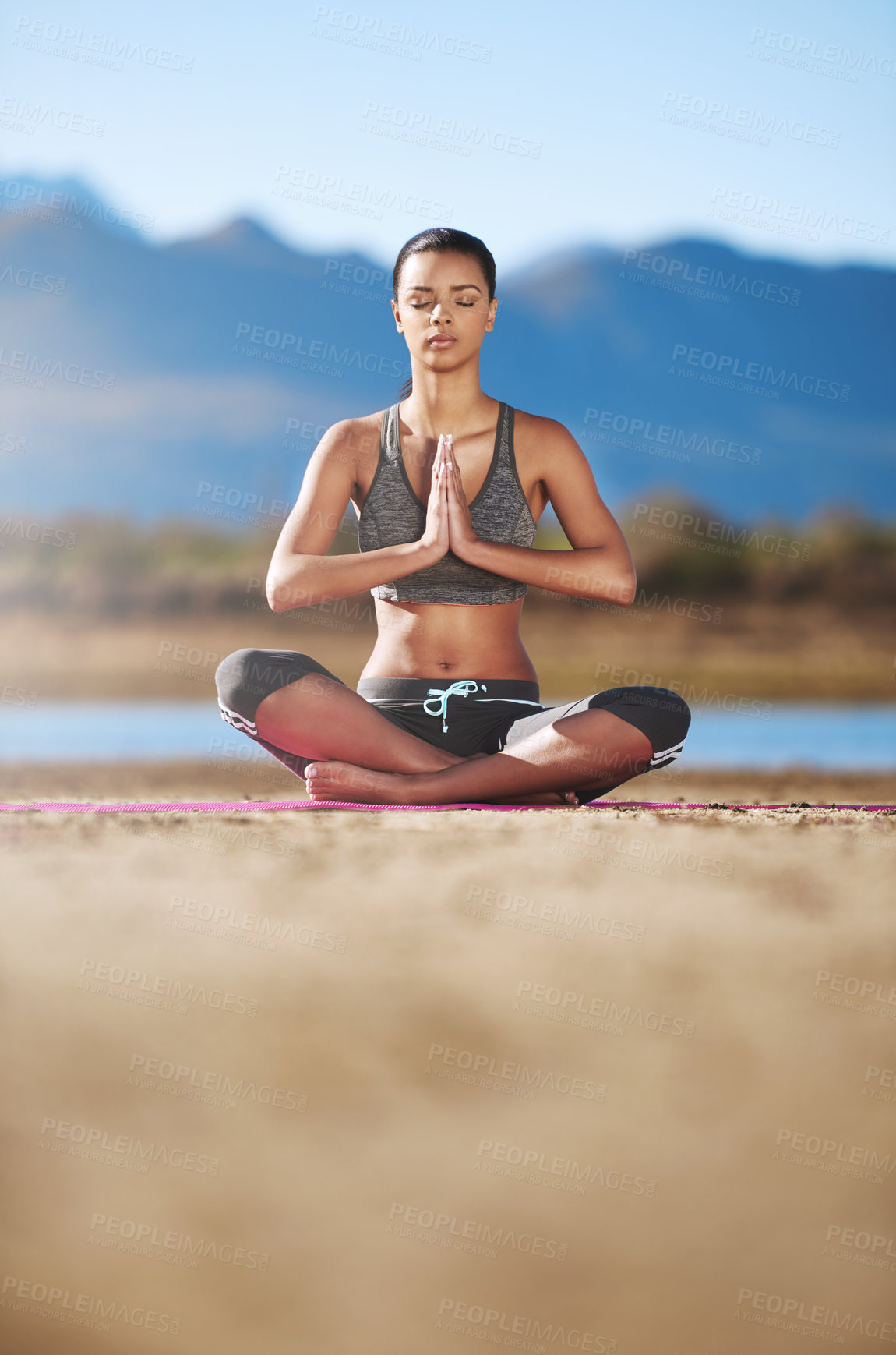Buy stock photo Shot of a young woman practising yoga outdoors