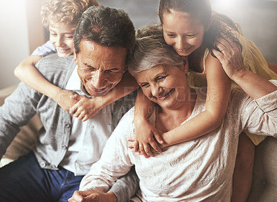 Buy stock photo Shot of grandparents spending time with their grandchildren at home