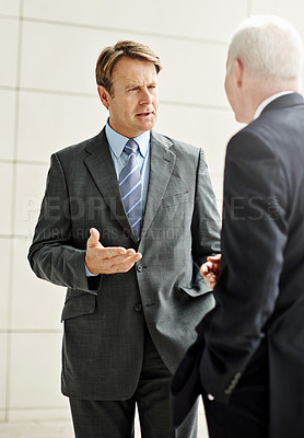 Buy stock photo Cropped shot of two businessmen talking in the lobby