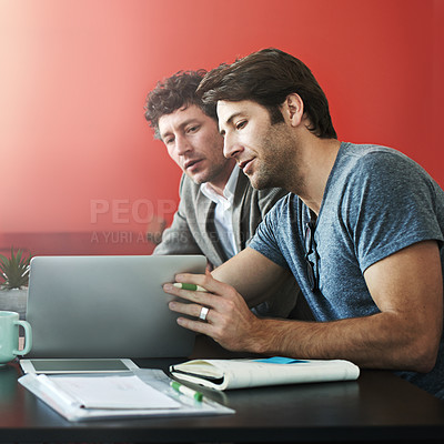 Buy stock photo Shot of a two coworkers talking together over a laptop in an office