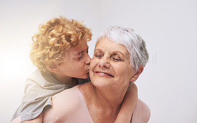 Buy stock photo Shot of a little boy giving his grandmother a kiss on the cheek