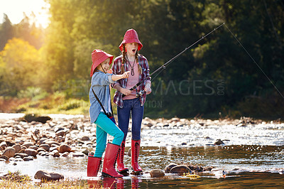 Buy stock photo Shot of two young girls fishing by a river