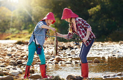 Buy stock photo Shot of two young girls fishing by a river