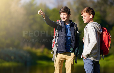 Buy stock photo Shot of two young boys wearing backpacks exploring nature together