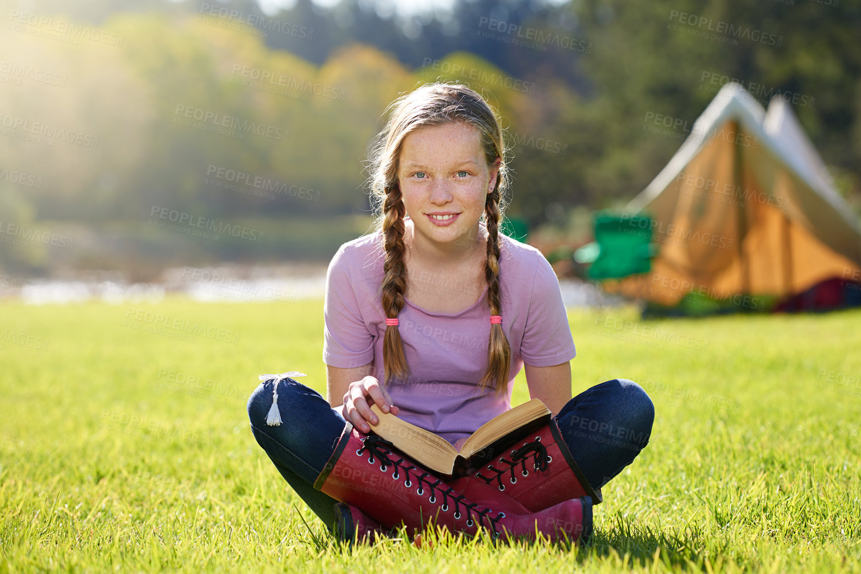 Buy stock photo Portrait, girl or book to relax, grass or imagine by story, freedom or vacation at summer camp. Young adult, fiction or smile by sitting, ground or nature park to wonder, fun or idea of fantasy dream