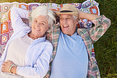 Buy stock photo Portrait of a happy senior couple relaxing together on the lawn
