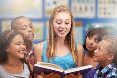 Buy stock photo Kids, tutor and reading a book in classroom for knowledge, learning or education with happiness. Group, students or teacher at school with study, textbook or smile and diversity at elementary college