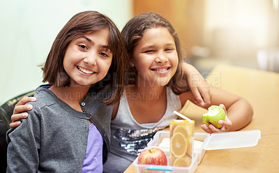 Buy stock photo Girls, hug and portrait with lunch at school for recess, break or nutrition at table with diversity. Kids, face and smile at academy or relax with confidence, food or embrace for friendship and care