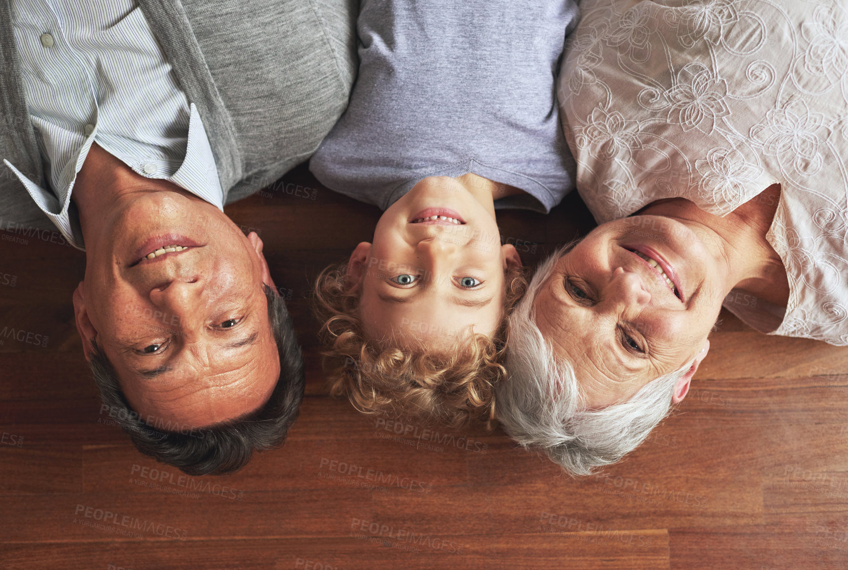 Buy stock photo Portrait, grandparents and boy on the floor, love and bonding together with joy or apartment. Family, face or old man with elderly woman, kid or grandchild with fun or cheerful with home or vacation