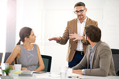 Buy stock photo A businessman explaining something to his colleagues in a meeting
