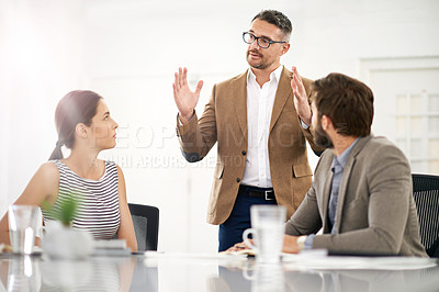 Buy stock photo A businessman explaining something to his colleagues in a meeting