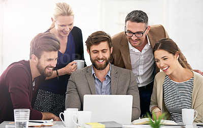 Buy stock photo Shot of businesspeople working together at a laptop