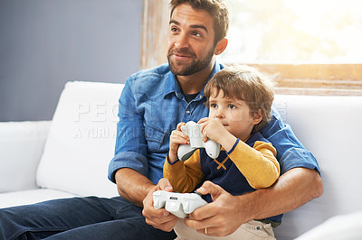 Buy stock photo Video games, father and son on a couch, playing and bonding for quality time, home and relax. Family, happy dad and boy with parent, male child and kid with controller, happiness and entertainment
