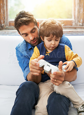 Buy stock photo Gaming, father and son on a sofa, video game and loving at home, quality time and relax in the lounge. Family, happy dad and boy with parent, male child and gamer playing online, cyber and carefree