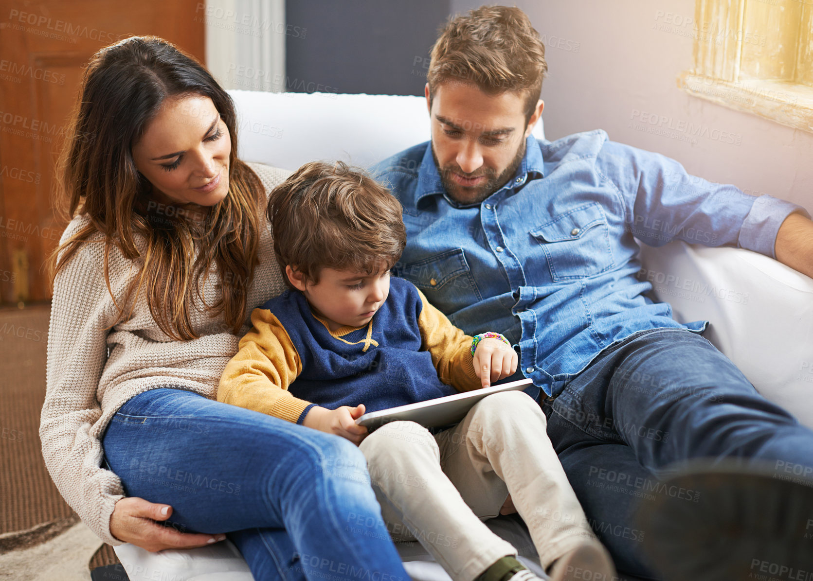 Buy stock photo Family, parents and child with tablet for streaming, relax on couch with cartoon or e learning games at home for bonding. Love, care and trust with digital tech, play online or people watch a movie