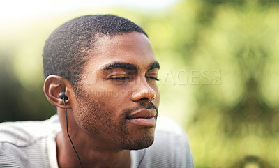 Buy stock photo Face, music and relax with black man in garden or park outdoor for summer, peace and quiet. Nature, radio and wellness with calm young person streaming audio or sound on earphones in backyard