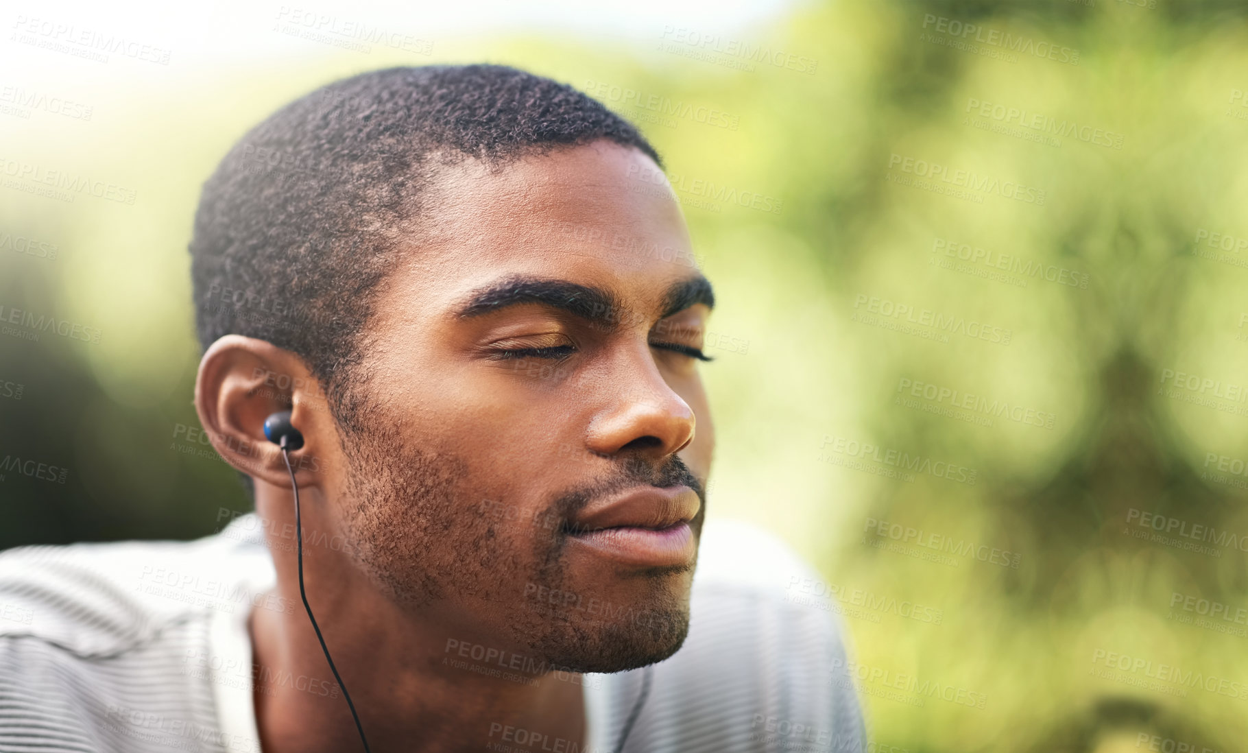 Buy stock photo Face, music and relax with black man in garden or park outdoor for summer, peace and quiet. Nature, radio and wellness with calm young person streaming audio or sound on earphones in backyard