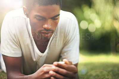 Buy stock photo Music, summer and earphones with black man on grass in garden, park or field to relax outdoor. Face, nature and wellness with young person streaming or listening to radio sound or audio in fresh air