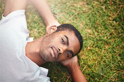 Buy stock photo Portrait, peace and black man on grass in garden of summer  for wellness or mindfulness. Face, relax and sunshine with confident young person lying in green field from above for break or rest
